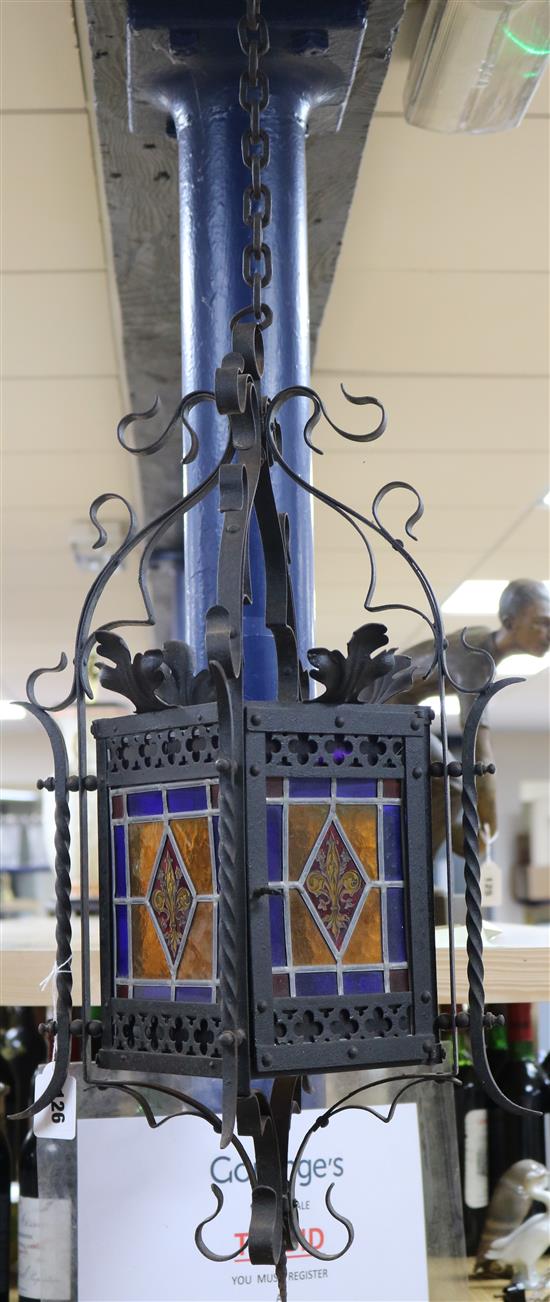 A wrought iron stained glass panel hanging lantern